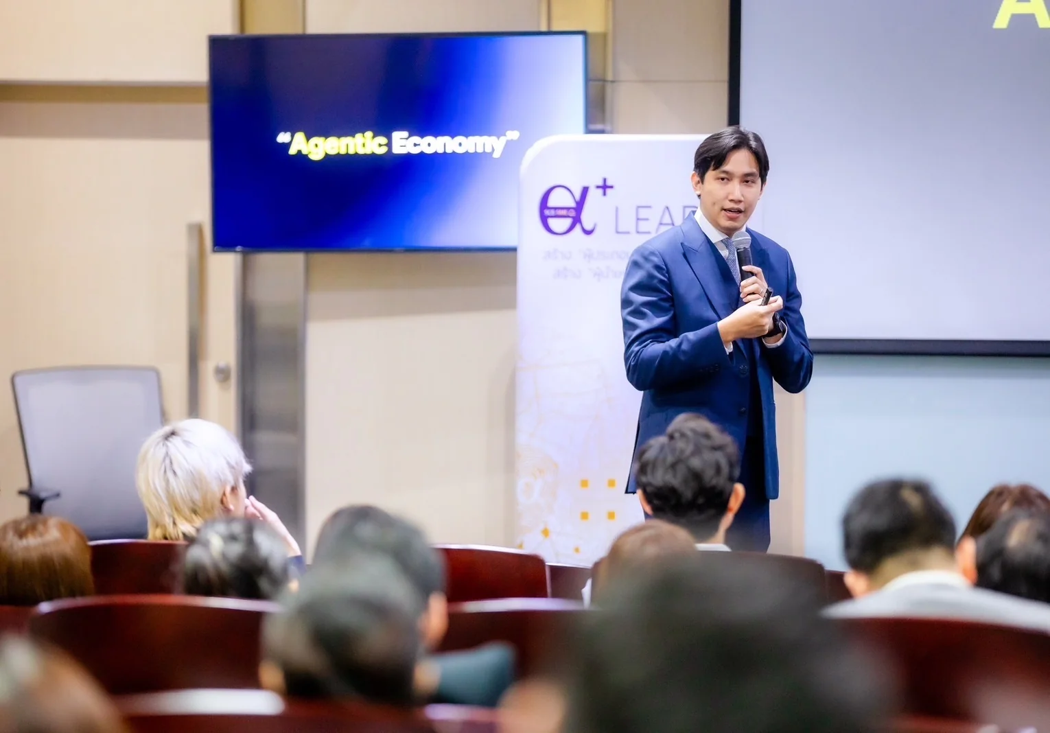 A business audience discussing the agentic economy with a speaker.